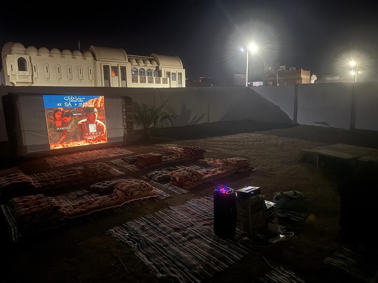 Outdoor cinema night at SA Studios, Dahab, with a film projected on the courtyard wall