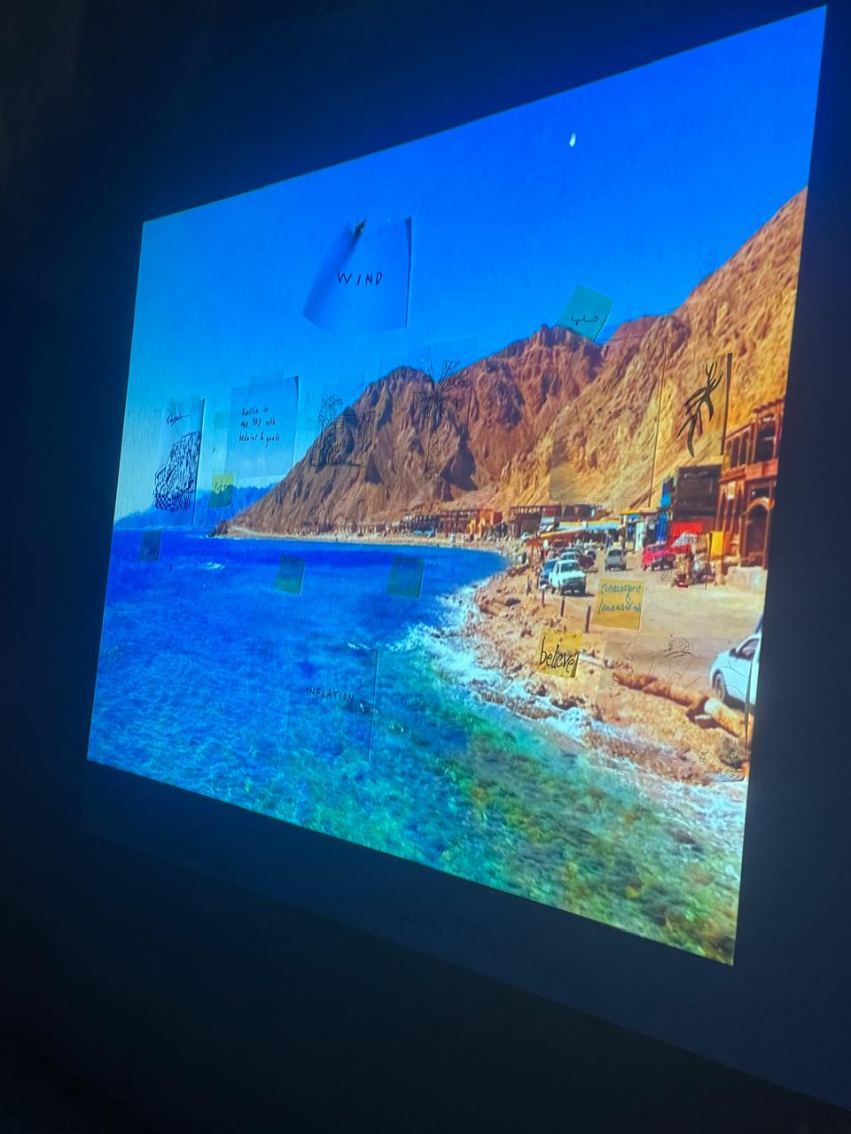 Projection of the Dahab coastline and mountains on a wall in the SA Studios gallery
